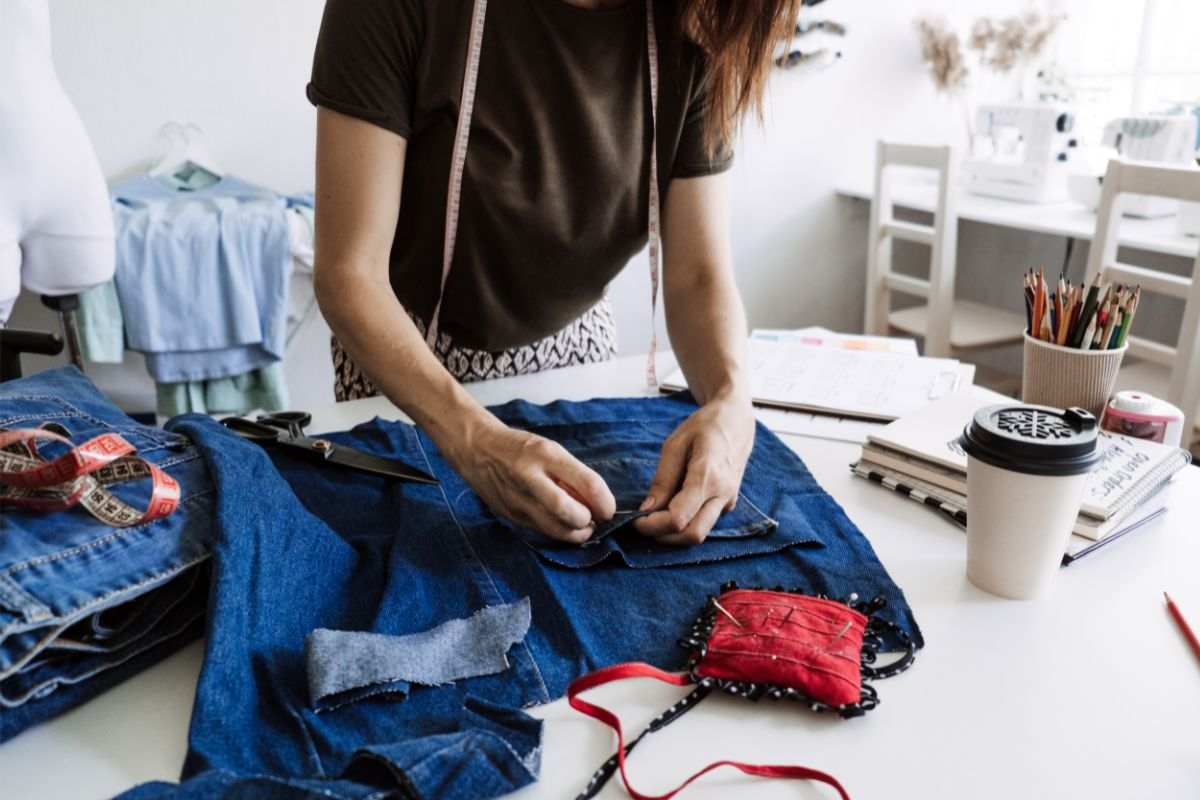 donna che cuce diversi jeans insieme