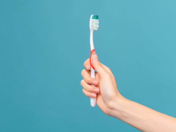 donna che impugna spazzolino da denti