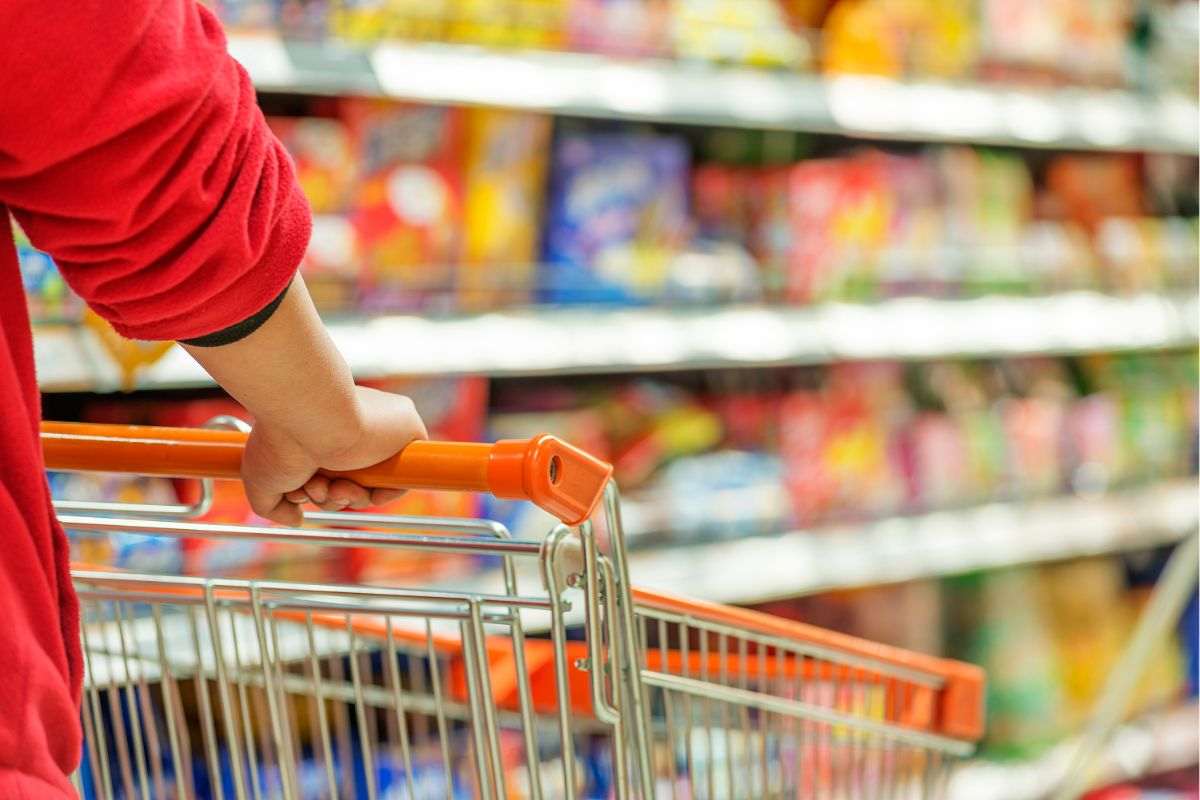 persona che spinge carrello nel supermercato