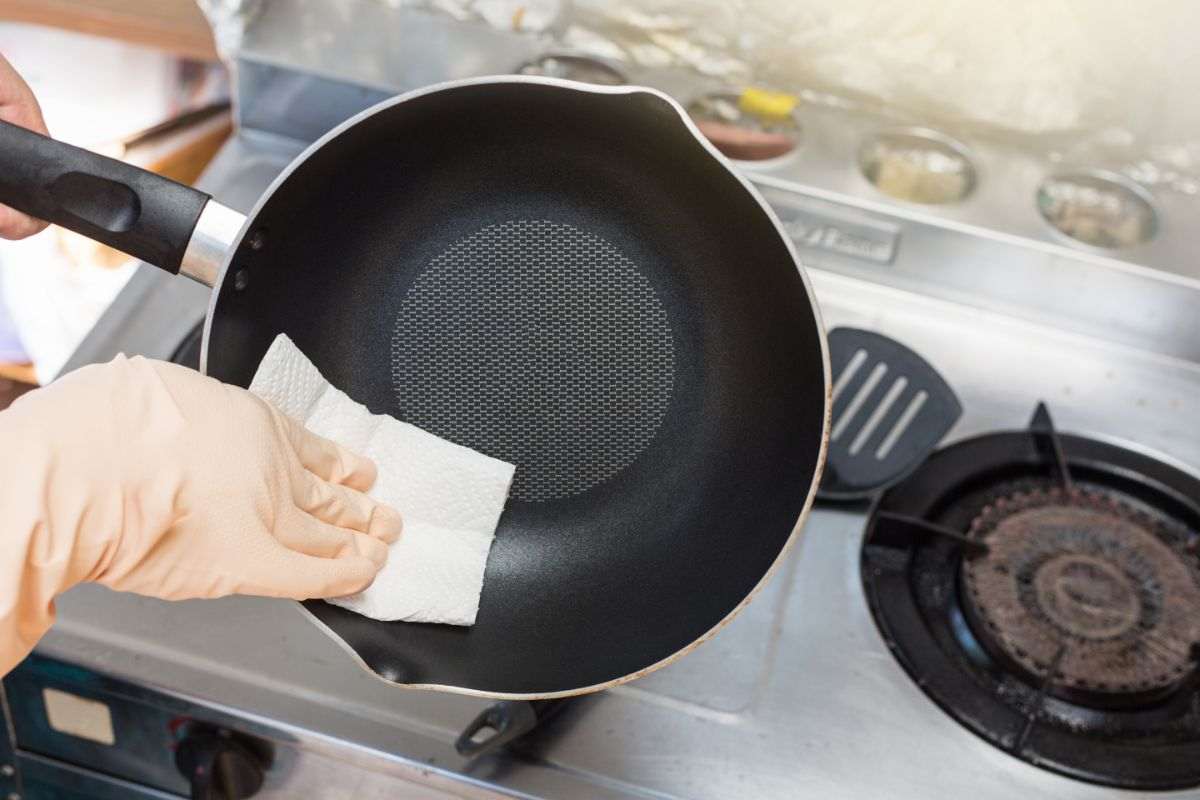 mano che pulisce padella