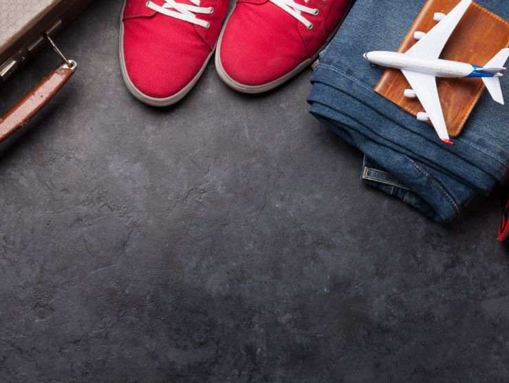 scarpe rosse, jeans piegato e modellino di aereo