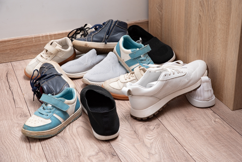 Qualche paio di scarpe disordinate sul pavimento in parquet da Lemn nel corridoio